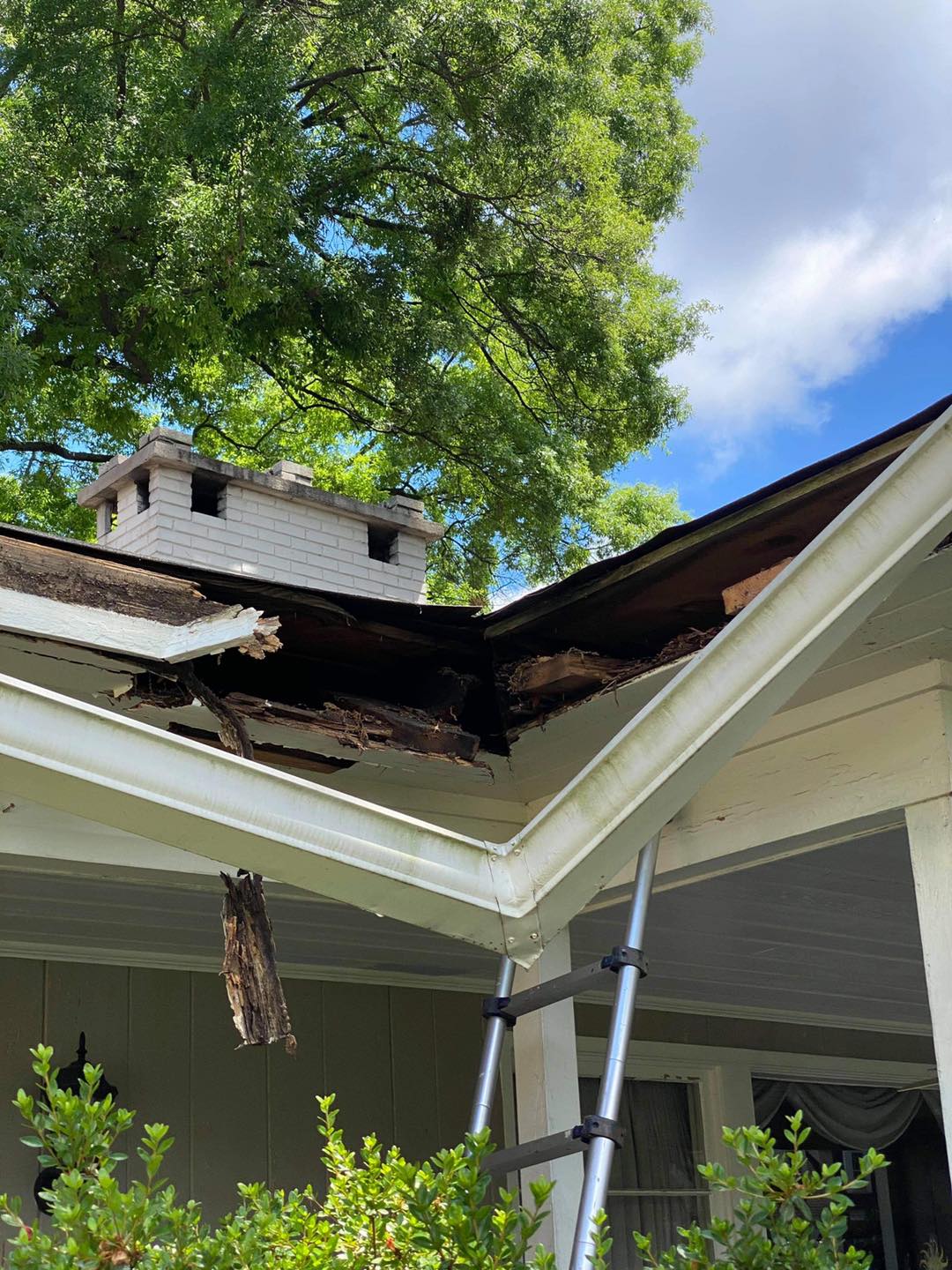 Rotted fascia board and roof damage before wood replacement